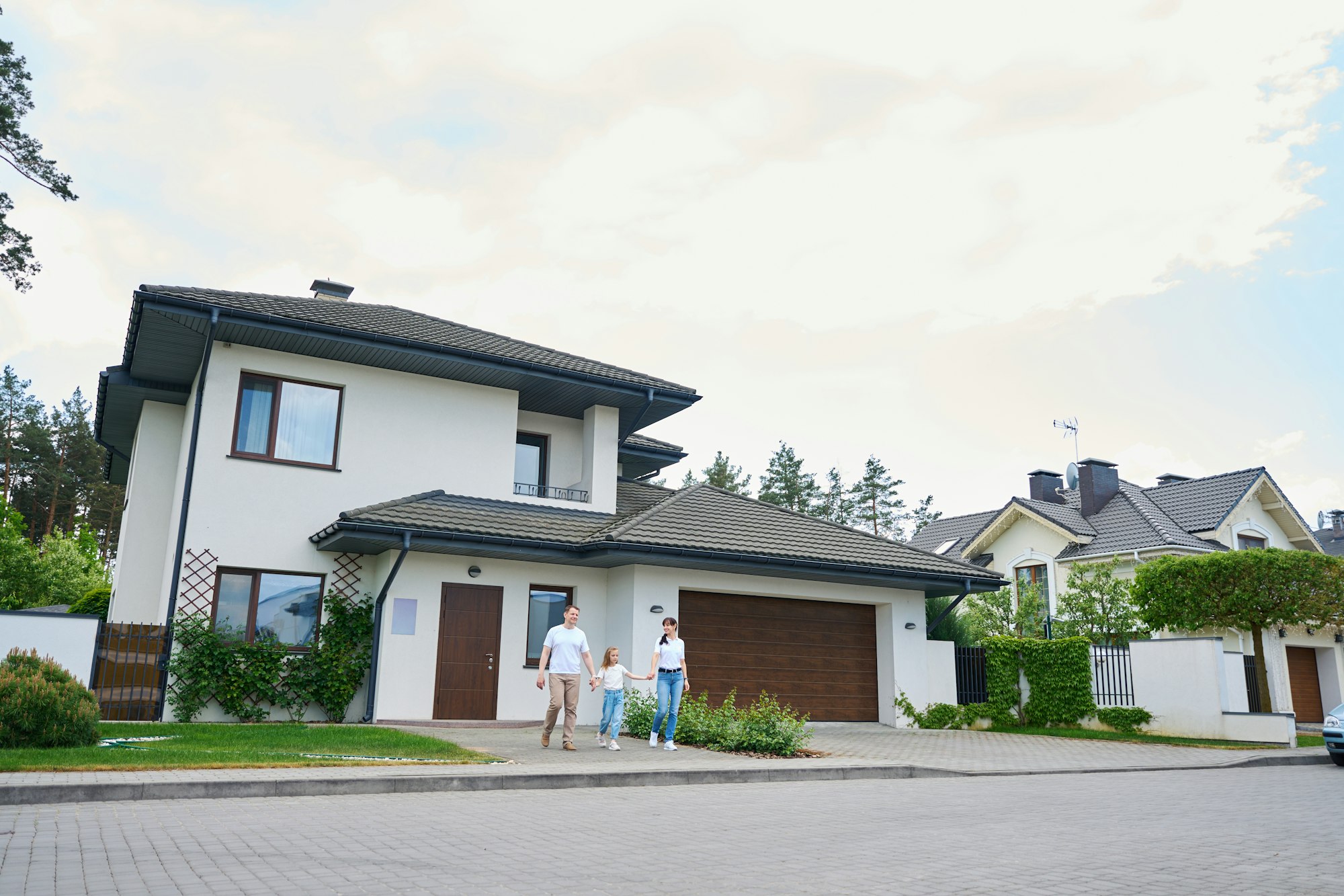 Family going from new modern townhouse outdoors in warm cloudy day